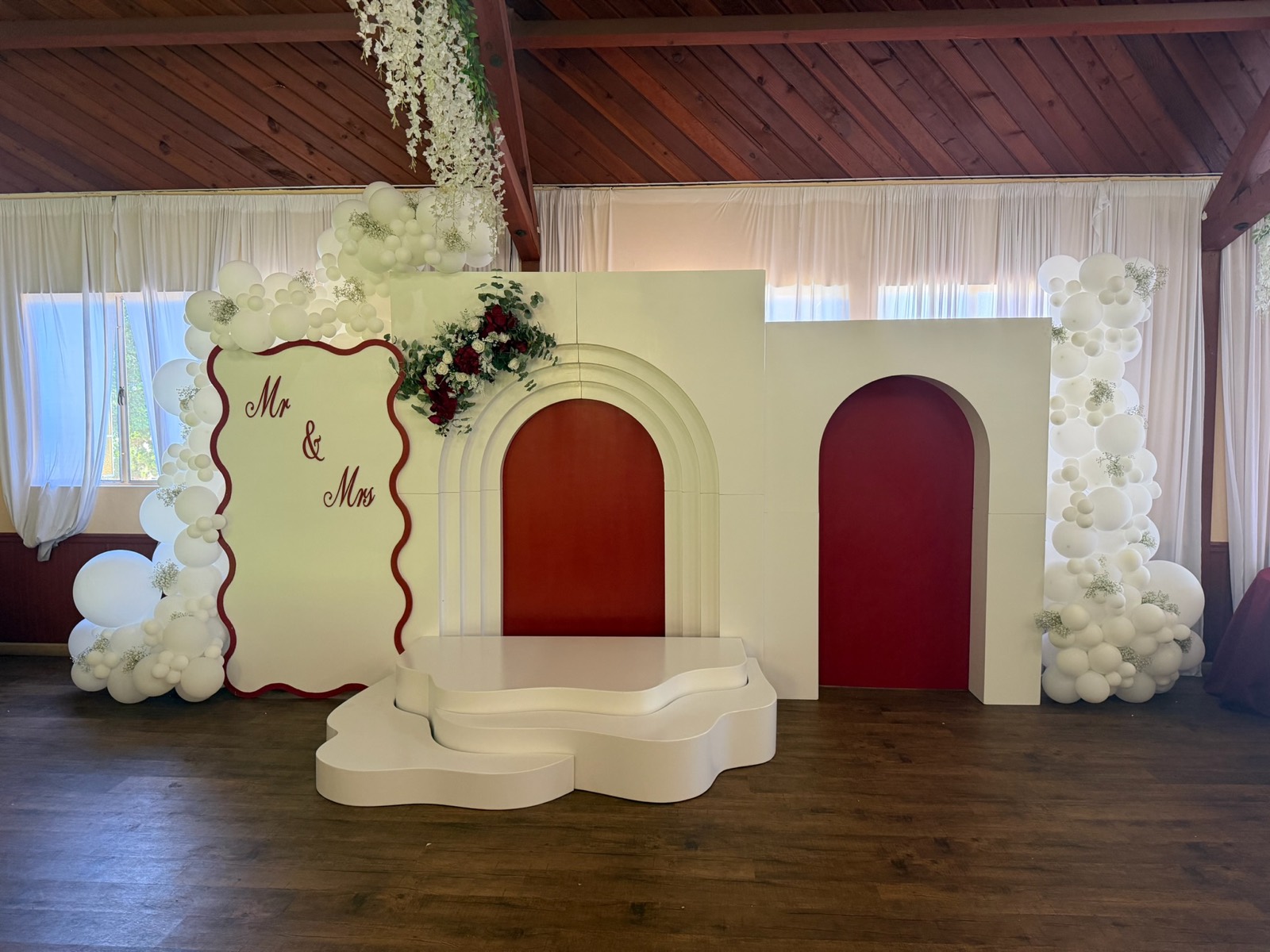 Elegant 'Mr & Mrs' wedding balloon backdrop with white garland and floral accents, designed by Turners Balloons & Events in San Diego
